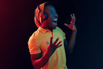 Image showing The young handsome hipster man listening music with headphones