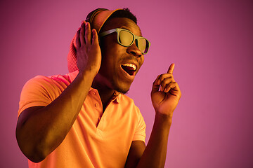 Image showing The young handsome hipster man listening music with headphones