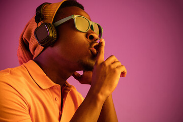 Image showing The young handsome hipster man listening music with headphones