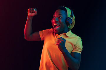 Image showing The young handsome hipster man listening music with headphones