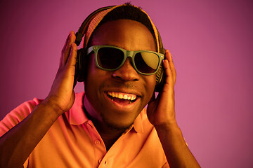 Image showing The young handsome hipster man listening music with headphones