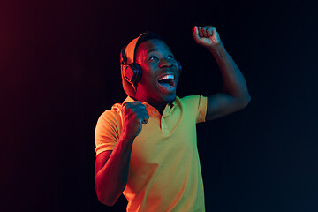 Image showing The young handsome hipster man listening music with headphones