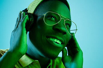 Image showing The young handsome hipster man listening music with headphones