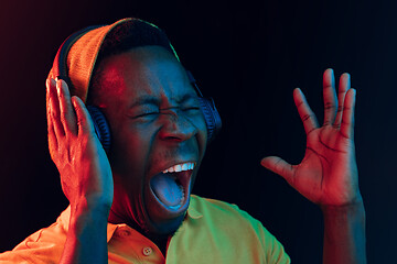 Image showing The young handsome hipster man listening music with headphones