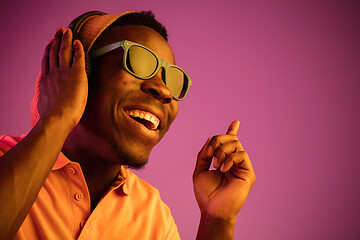 Image showing The young handsome hipster man listening music with headphones