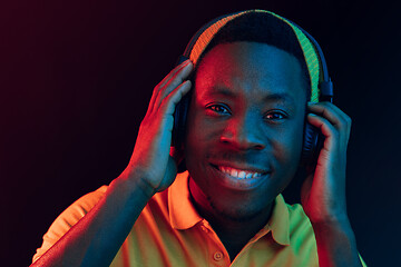 Image showing The young handsome hipster man listening music with headphones