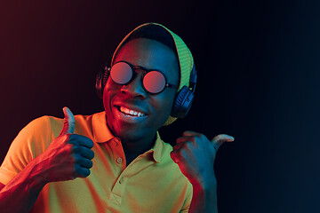 Image showing The young handsome hipster man listening music with headphones