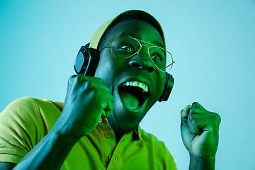 Image showing The young handsome hipster man listening music with headphones