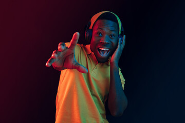 Image showing The young handsome hipster man listening music with headphones