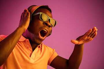 Image showing The young handsome hipster man listening music with headphones