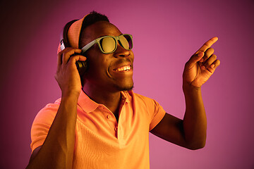 Image showing The young handsome hipster man listening music with headphones