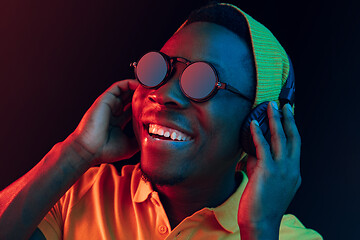 Image showing The young handsome hipster man listening music with headphones