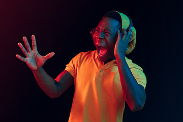 Image showing The young handsome hipster man listening music with headphones