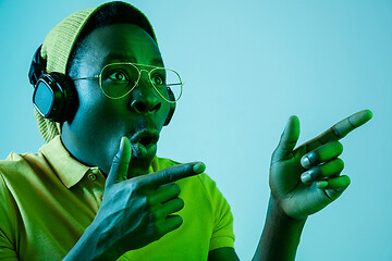 Image showing The young handsome hipster man listening music with headphones