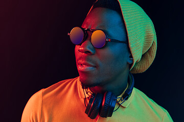 Image showing The young handsome hipster man listening music with headphones