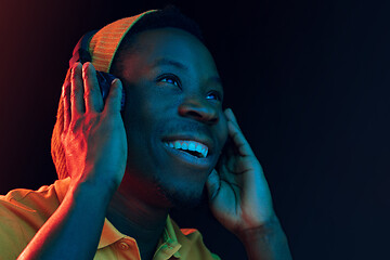 Image showing The young handsome hipster man listening music with headphones