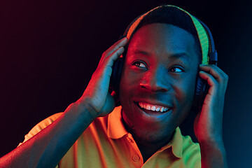 Image showing The young handsome hipster man listening music with headphones