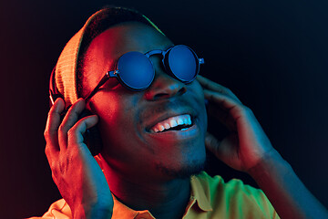 Image showing The young handsome hipster man listening music with headphones