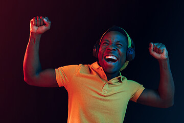 Image showing The young handsome hipster man listening music with headphones