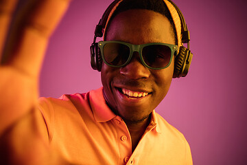 Image showing The young handsome hipster man listening music with headphones