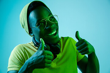 Image showing The young handsome hipster man listening music with headphones