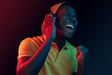 Image showing The young handsome hipster man listening music with headphones