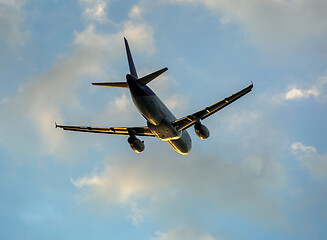 Image showing Airplane in clouds at sunset