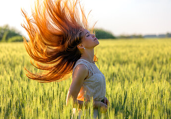 Image showing girl with blowing red hair