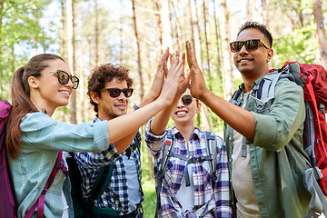 Image showing friends with backpacks hiking and making high five