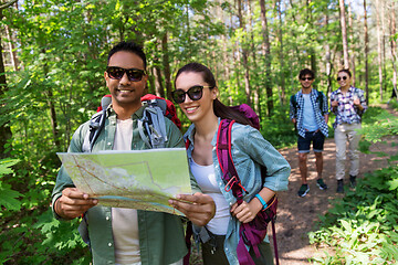 Image showing friends with map and backpacks hiking in forest