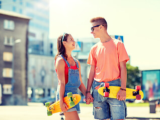 Image showing teenage couple with skateboards on city street