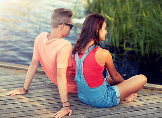 Image showing happy teenage couple sitting on river berth