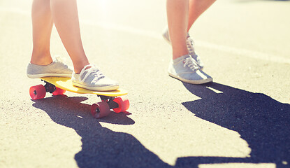 Image showing feet of teenage couple riding skateboard on road