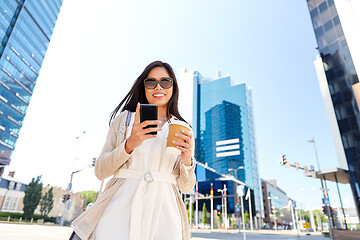 Image showing smiling woman with smartphone and coffee in city