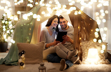 Image showing happy couple with tablet pc in kids tent at home