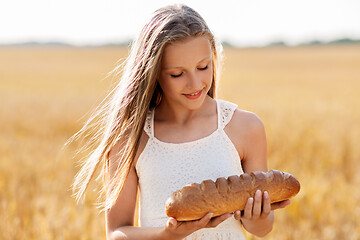 Image showing girl with loaf of white bread on cereal field