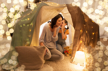 Image showing happy family whispering in kids tent at home