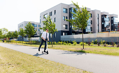 Image showing young businessman riding electric scooter outdoors