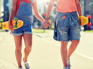 Image showing close up of young couple with skateboards in city