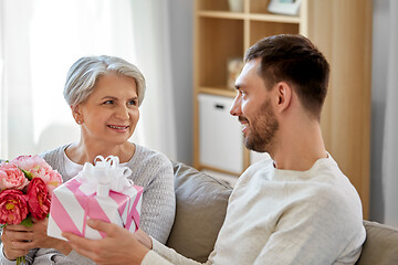 Image showing son giving present and flowers to senior mother