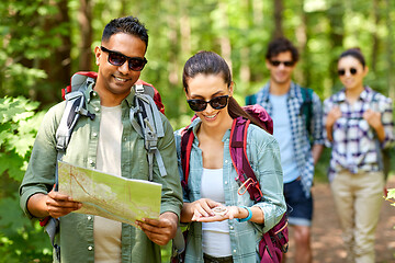 Image showing friends with map and backpacks hiking in forest