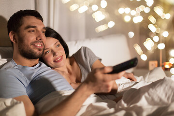 Image showing happy couple watching tv in bed at night at home