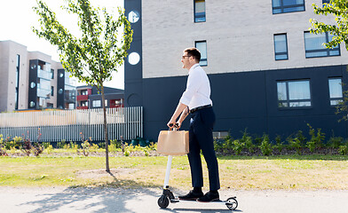 Image showing businessman with takeaway lunch riding scooter
