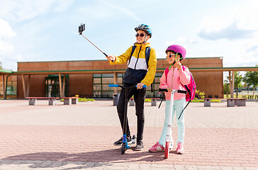 Image showing happy school kids with scooters taking selfie