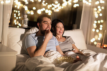 Image showing couple with popcorn watching tv at night at home