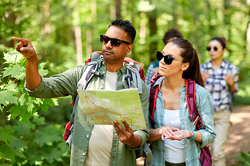 Image showing friends with map and backpacks hiking in forest