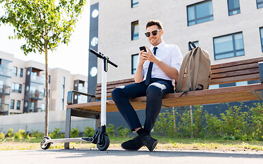 Image showing businessman with smartphone, backpack and scooter