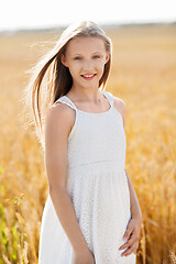 Image showing smiling young girl on cereal field in summer