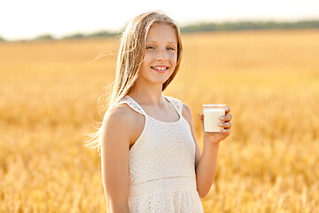 Image showing happy girl with glass of milk on cereal field