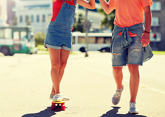 Image showing teenage couple riding skateboard on city street